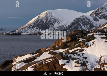 Robuste, schneebedeckten Berge entlang der Küste einer Insel, Lofoten, Nordland, Norwegen Stockfoto