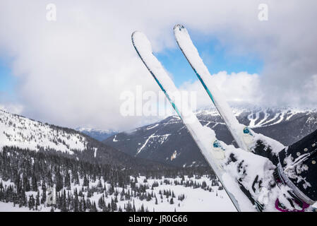 Schnee Skier für Skifahrer ein Sitzen auf einem Sessellift mit Blick auf die verschneite Wald und die Berge in einem Ski Resort Stockfoto