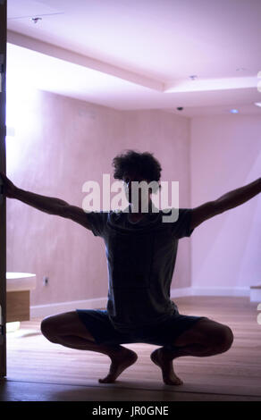 Männliche Yogalehrer tun teilt Bein Strecken Flexibilität Gymnastik und Yoga Asanapraxis im Fitness-Studio Stockfoto