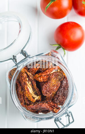 Getrocknete Tomaten in Glas und frischen Tomaten. Tomaten als Superfood. Ansicht von oben. Stockfoto