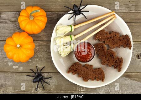 Halloween Party Essen mit Fledermaus Brote und Hexen Besen, obenliegende Szene auf rustikalen Holz Stockfoto