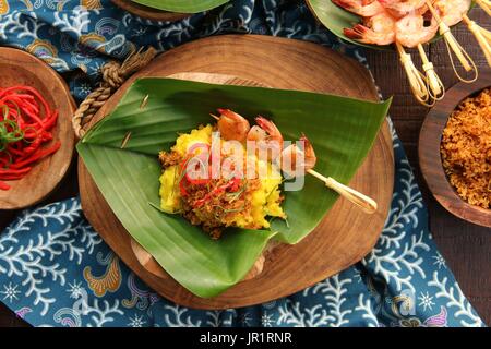 Ketan Serundeng Udang. Gelbwurz Klebreis mit Roasted Coconut und Garnelen Satay Stockfoto