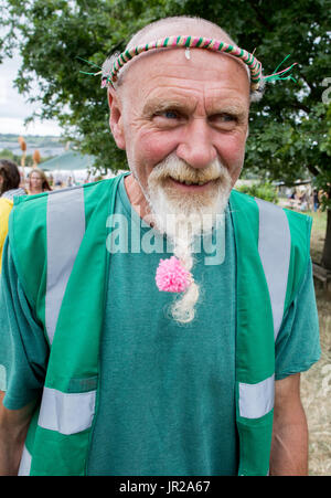 Alter Hippie mit einem rosa Blume in seinen Bart Glastonbury Festival in Großbritannien Stockfoto
