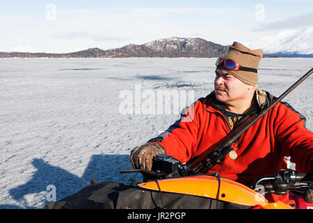 Jäger auf einem Atv Während ein Süßwasser-Hafen Robbenjagd, Lake Iliamna, Pedro Bay, Southcentral Alaska, USA Stockfoto