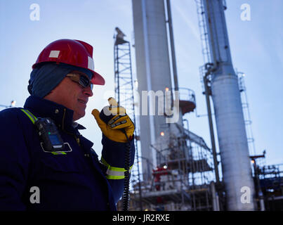 Handwerker Sprechen in Radio während der Arbeit in einer Raffinerie; Edmonton, Alberta, Kanada Stockfoto