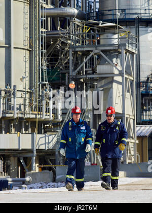 Zwei Handwerker gemeinsam zu Fuß in einer Raffinerie; Edmonton, Alberta, Kanada Stockfoto