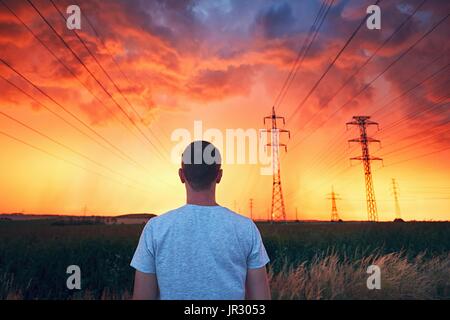 Das Wetter ist gefährlich. Einsamer Mann in atemberaubenden Sturm während der farbenprächtigen Sonnenuntergang. Stockfoto