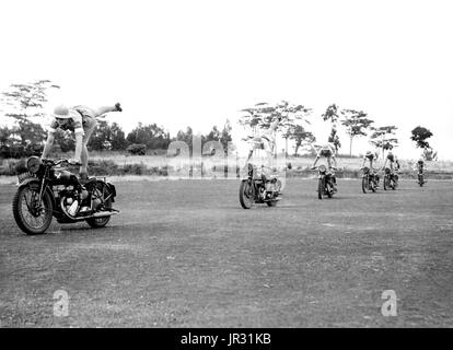 Britische Frauen Versand Fahrer. South African Mädchen, nach England ging, um die "erste-Hilfe und Pflege Yeomanry" beitreten, lernen Stunt riding um Balance und Vertrauen im Umgang mit ihren Maschinen zu geben. Ein Versand ist ein militärischer Bote, auf Pferd oder Motorrad montiert. Im Vereinigten Königreich ist "Meldereiter" die am weitesten verbreitete Bezeichnung für einen Motorrad-Kurier. Versand Fahrer wurden von Streitkräften verwendet, um dringende Bestellungen und Nachrichten zwischen der zentrale und militärische Einheiten zu liefern. Im zweiten Weltkrieg, Royal Corps of Signals Soldaten durchgeführt, die Rolle und das königliche Signale Motorrad Display Team wurde gebildet aus ihrer Stockfoto