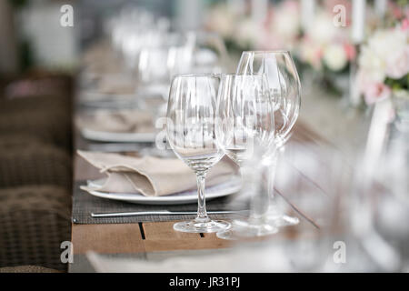 Gedeckter Tisch, ein Teller mit übersichtlich angeordneten Serviette, Messer und Gabel. Schön dekorierten Tisch mit weißen Platten, Kristallgläser, Bettwäsche Serviette. Stockfoto