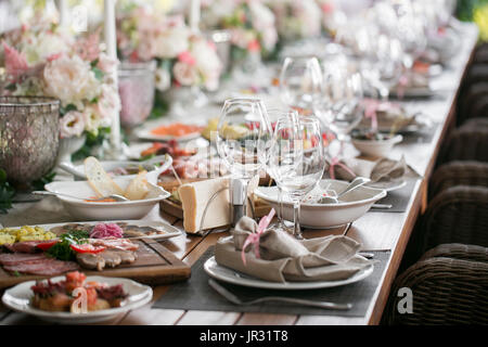 Gedeckter Tisch, ein Teller mit übersichtlich angeordneten Serviette, Messer und Gabel. Schön dekorierten Tisch mit weißen Platten, Kristallgläser, Bettwäsche Serviette. Stockfoto