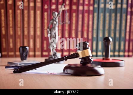 Court Judge Hammer, Themis - die Göttin der Gerechtigkeit, Notar Stamper und Gesetzestexte im Hintergrund. Anwaltskanzlei. Gesetz-Konzept. Stockfoto