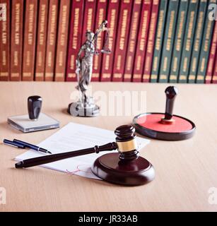 Court Judge Hammer, Themis - die Göttin der Gerechtigkeit, Notar Stamper und Gesetzestexte im Hintergrund. Anwaltskanzlei. Gesetz-Konzept. Stockfoto