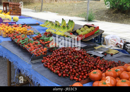 Vouliagmeni Griechenland Samstag Marktstand mit Tomaten, roten Kirschen, Erdbeeren, Bananen, Aprikosen und Birnen Stockfoto