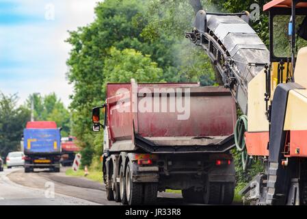 Straßenarbeiten. Asphalt entfernen Maschine laden in Pulverform Asphalt auf dem LKW Stockfoto