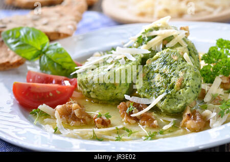 Südtiroler Semmelknödel mit Spinat und Käse, serviert mit Butter, Parmesan und Walnüssen Stockfoto