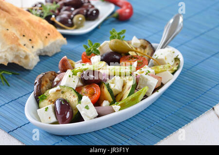 Griechische gebratenes Gemüse mit Feta-Käse und Kalamata Oliven, Fladenbrot im Hintergrund Stockfoto