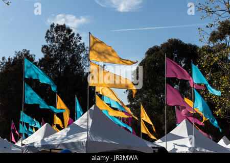 Bunte Fahnen auf Karneval Zelte gegen den blauen Himmel fliegen Stockfoto