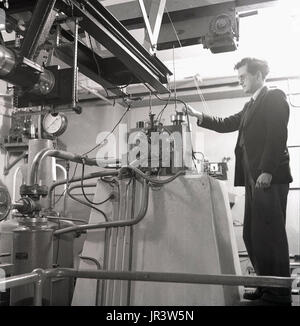 1950, historische, männliche Professor an der Universität Oxford, Oxford, England, Großbritannien, mit einem ultracentrifuge Maschine im biochemischen Labor. Stockfoto