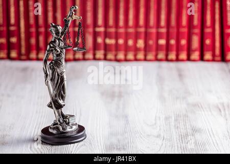 Statuette der Themis das Symbol des Gesetzes über die alten Holzboden mit zugelassenen Codes. Gesetz-Konzept Stockfoto