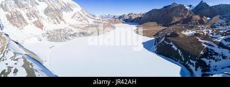 Luftaufnahme von großer Höhe Tilicho See zugefroren und bedeckt mit Schnee in den Bergen des Himalaya in Nepal Stockfoto