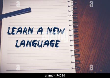 Lernen eine neue Sprache geschrieben auf weißem Papier, Bildungskonzept Stockfoto