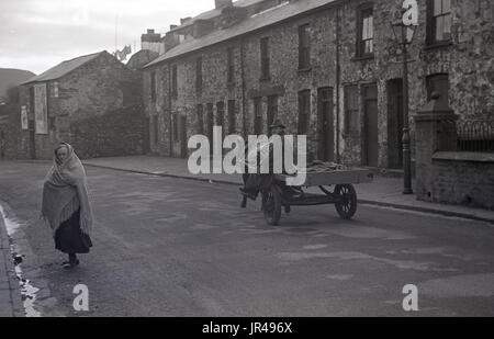 1940 s, historischen, Mann auf Pony und Warenkorb in einer ruhigen Strasse von kleinen viktorianischen Reihenhäusern in Merthyr Tydfil, South Wales. Er würde den Verkauf von Herzmuscheln, die er vom lokalen Strand bezogen hatte, von Tür zu Tür. Stockfoto