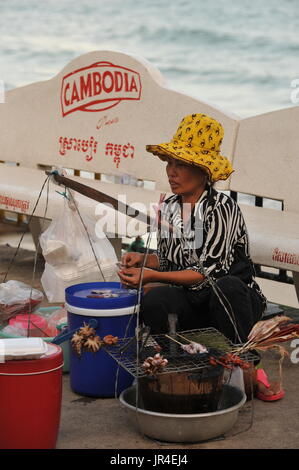 Mobiler Tintenfisch-Anbieter mit kambodschanischer Bierwerbung im Hintergrund, Serendipity Beach, Sihanoukville, Kampong Som, Kambodscha. © Kraig Lieb Stockfoto