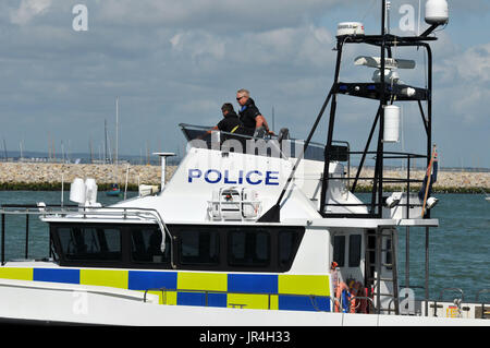 Polizisten bei der Cowes Week auf der Isle Of Wight Polizeiarbeit auf dem Beat und der Polizei auf dem Wasser in einem Polizei-Boot oder Stich Westen starten body protector Stockfoto