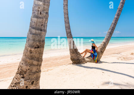 Juanillo Beach (playa Juanillo), Punta Cana, Dominikanische Republik. Frau unter hohen Palmen am Strand. Stockfoto