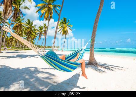 Canto de la Playa, Saona, East National Park (Parque Nacional del Este), Dominikanische Republik, Karibik. Frau entspannen auf einer Hängematte. Stockfoto