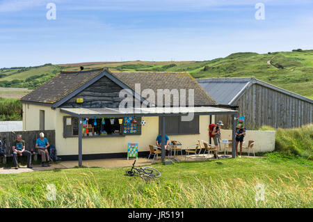 Cafe am Gunwalloe Beach, Lizard Peninsula, Cornwall, Großbritannien im Sommer mit Wanderer am South West Coast Path Stockfoto