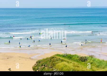 Surfschule mit Menschen beim Lernen zu surfen Poldhu Cove UK Beach, Cornwall, Großbritannien Stockfoto