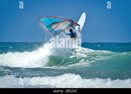 Windsurfen-Sprünge aus dem Wasser sehr hoch über der Welle Stockfoto