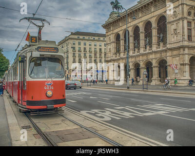Wien, Österreich - 23. Mai 2017: Old Fashion Straßenbahn auf einer Straße von Wien. im Hintergrund Wiener Staatsoper Stockfoto