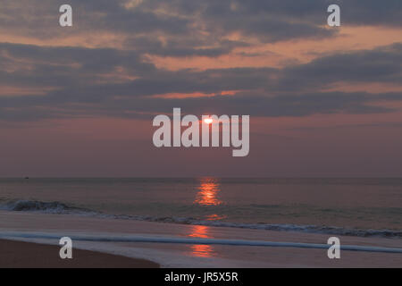 Schöner Sonnenuntergang am Strand von Cabo Ledo Angola. Mit Wellen. Dramatischer Himmel. Stockfoto