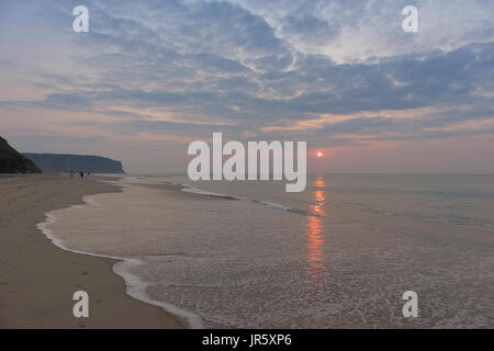 Schöner Sonnenuntergang am Strand von Cabo Ledo Angola. Mit Wellen. Dramatischer Himmel. Stockfoto