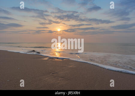 Schöner Sonnenuntergang am Strand von Cabo Ledo Angola. Mit Wellen. Dramatischer Himmel. Stockfoto