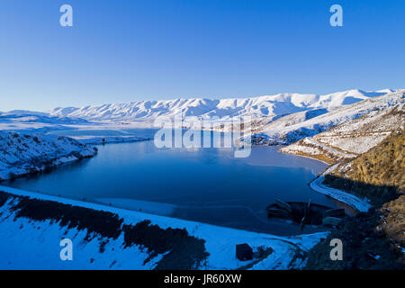 Fällt Dam und Hawkdun im Winter, Maniototo, Central Otago, Südinsel, Neuseeland - Drohne Luftbild Stockfoto