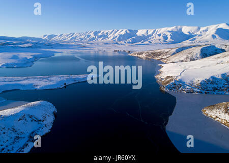 Fällt Dam und Hawkdun im Winter, Maniototo, Central Otago, Südinsel, Neuseeland - Drohne Luftbild Stockfoto