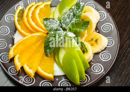 Veganes Frühstück: Auswahl an Früchten, Nüssen und Beeren auf dem grauen Holztisch, selektiven Fokus Stockfoto