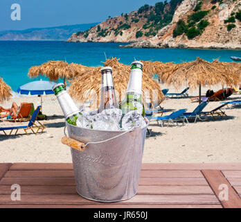 Drei ungeöffnete Flaschen Bier im Eiskübel auf Strand Hintergrund Stockfoto