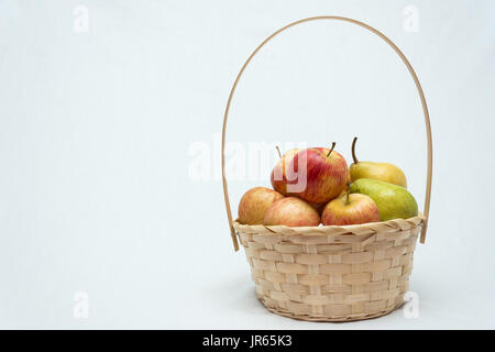 Korb mit Äpfeln und Birnen auf weißem Hintergrund Stockfoto