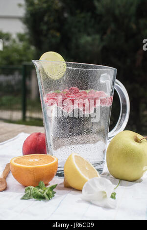 Krug und Glas Wasser mit frischen Früchten Stockfoto