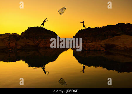 Silhouette von zwei Fischern werfen Netze miteinander bei Sonnenaufgang, Thailand Stockfoto