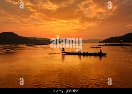 Silhouette von zwei Fischern in einem Boot bei Sonnenuntergang, Thailand Stockfoto