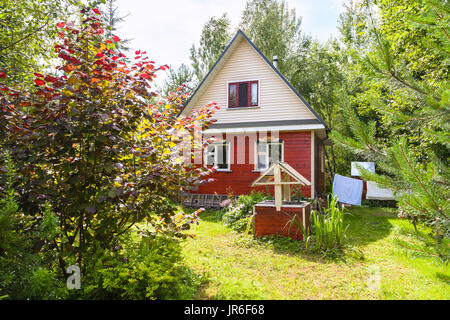 neue Hütte und gut auf Hinterhof in russischen Dorf am sonnigen Sommertag Stockfoto