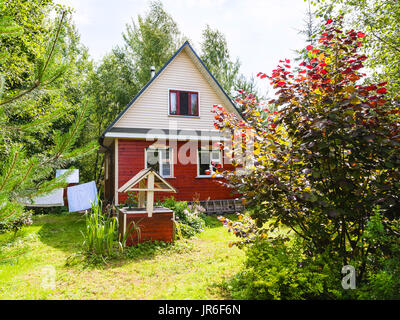 Holzhaus und gut auf Hinterhof in russischen Dorf am sonnigen Sommertag Stockfoto