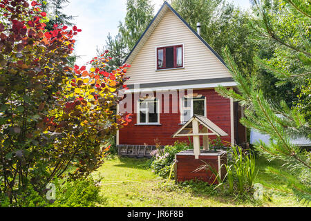 einfache Hütte und gut auf Hinterhof in russischen Dorf am sonnigen Sommertag Stockfoto