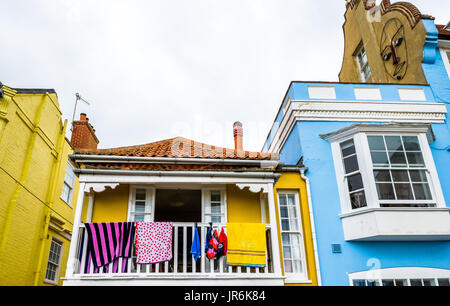 Handtücher trocknen auf einem weißen wetterte Balkon eines gelb gestrichenen Haus. Stockfoto