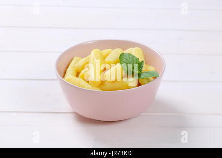 Schüssel mit gekochten Kartoffeln Kegel oder Gnocchi auf weißem Holz Hintergrund Stockfoto